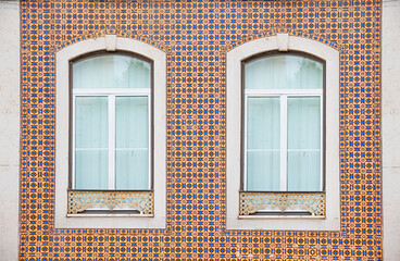 two arched windows at historic facade with colorful azulejos tiles