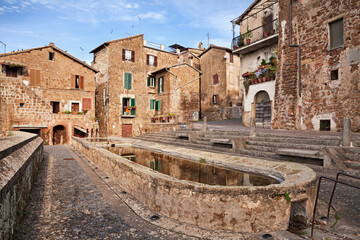Fototapeta na wymiar Sutri, Viterbo, Lazio, Italy: cityscape of the medieval town with the anciient public wash house in the picturesque square