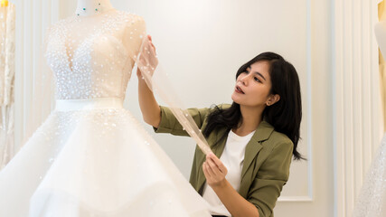 Female bridal store owner work in wedding studio shop. Owner Of Bridal Wedding Dress Shop Work in...