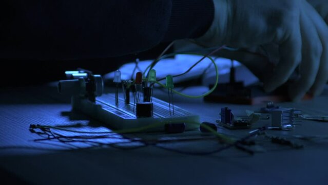 An engineer working on artificial intelligence Arduino project, breadboard electronic module on the desk