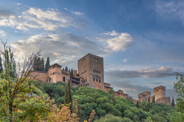 Fototapeta na wymiar Amazing view of the Sabika hill with the ruins of the ramparts, watchtowers and Alhambra Palace from the Carrera Del Darro street. Sunny day with an amazing sky.