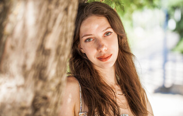 Close up portrait of a young beautiful girl in summer park