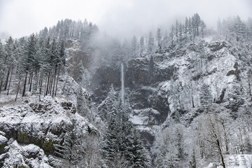 "Portland, Oregon \ USA - December 28 2021: View at famouus Multnomah falls at Columbia Gorge during massive snowfall"