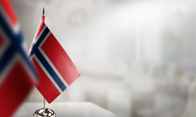 Small flags of the Norway on an abstract blurry background