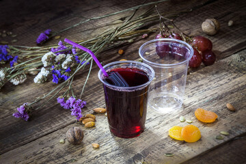 Grape juice in a disposable plastic glass with a tube