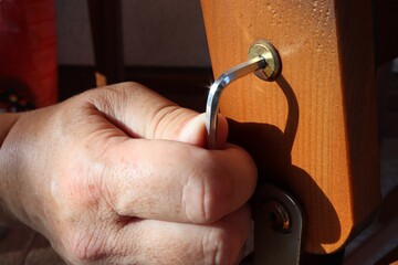 Close-up of a hand tightening a loose screw. Focused on the screw and Allen key.
