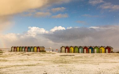 The colorful beach huts at Blyth beach surrounded by snow in a wintery Northumberland, England