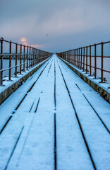 Naklejka premium A freezing, snowy morning at Blyth beach at the old wooden Pier stretching out to the North Sea