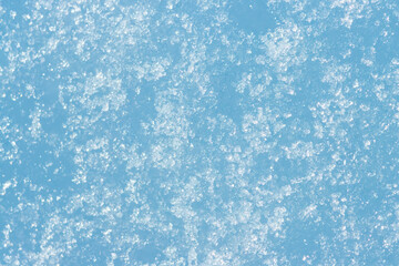 Snow texture. Snow surface with snowflakes and crystals close-up. Shallow depth of field. Winter background with snow patterns. Perfect for Christmas and New Year design.