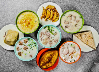 Assorted porridge with Raw Rolled Pig, beef, meatball, Preserved Egg Lean, Sliced ​​Fish, leg crispy, Pumpkin Polenta, Steamed Carrot Cake, egg yolk bacon fried dumpling, top view of hong kong food