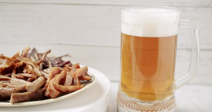Craft Beer into the large glass. Beer Mug. On a white background. Half a liter, close up. Rotation 360 degrees. Glass full of beer with plate minced meat, and snacks. bbq meat set for beer snack. 