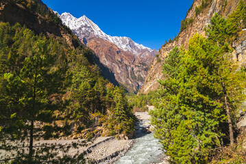 River cutting through Annapurna mountain range on a sunny cloudless fall day