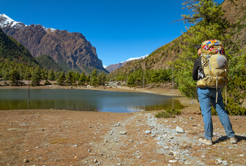 Female trekker looking at view of small lake on the Annapurna Circuit Trek, Nepal