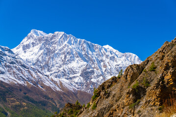Fototapeta na wymiar Picturesque landscape of the Annapurna Circuit trek with footpath on a sunny fall day