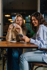 Two young women spend time together in a cafe