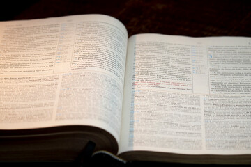 Holy bible open on a wooden table with a bookmark in the middle of the book