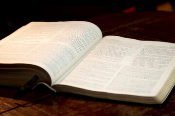 holy bible open on a wooden table