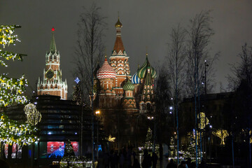 Fototapeta na wymiar Christmas decorations on winter Red Square in Moscow, Russia. Illuminated St. Basil's Cathedral and tall Christmas tree. Evening cityscape with bright night lights. New Year celebration.