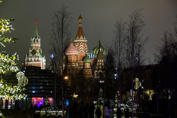 Christmas decorations on winter Red Square in Moscow, Russia. Illuminated St. Basil's Cathedral and tall Christmas tree. Evening cityscape with bright night lights. New Year celebration.