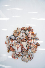 Southwestern river beach stones on a white background arranged in a contemplative altar mandala. 