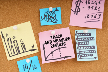 On the board are stickers with graphs and diagrams and the inscription - Track And Measure Results
