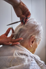 caregiver, cutting her elderly woman hair