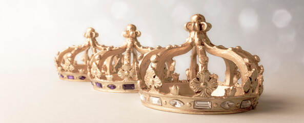 Happy Three King's Day. Three golden color crowns on light background. Concept for Reyes Magos,...