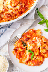 Sorrentina-style potato Gnocchi with tomato sauce, mozzarella cheese and basil on a with background