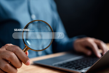 Businessman use magnifying glass Search On Virtual Screen Data Search Technology Search Engine Optimization. Man use computer to Searching for information. Using Search Console for data.