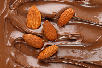 Chocolate cream with almond nuts. Sauce, paste, syrup. Background of  Liquid chocolate. Curl....