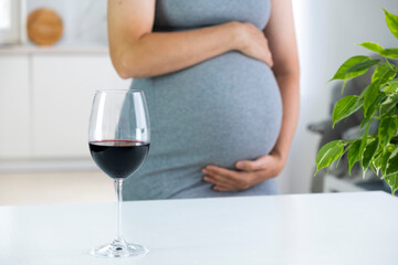 Pregnant woman and glass of wine. Future mother and healthy lifestyle. Prenatal care about health...