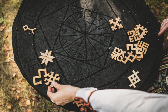 Wooden cut out Latvian pagan signs and symbols for ceremonies on a black wood background