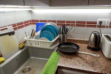 Drying clean dishes on a rack in a simple kitchen