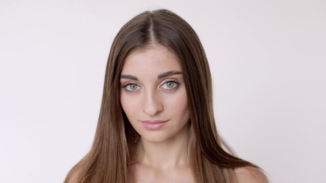 Portrait of a pretty young Middle Eastern model with bare shoulders. The model is isolated on a white studio background.