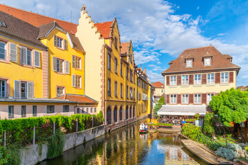 Fototapeta na wymiar Colorful half timbered buildings and waterfront cafes on the Lauch River in the historic medieval Little Venice district of Colmar, France, in the Alsace region.
