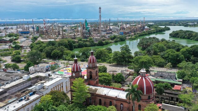 Domes of a church with an oil refinery plant in the background in the city of Barrancabermeja. Colombia.