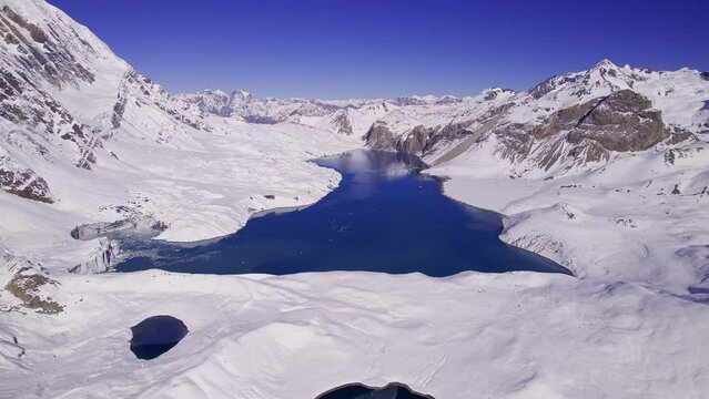 Aerial view of Tilicho Lake in Khangsar Nepal in the Himalayan Mountains with snow surrounding the landscape.