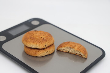 A pack of cookies on an electronic kitchen scale, accurate calorie counting, proper nutrition, diet.