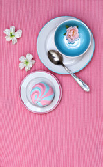 Vertical banner with colorful striped fluffy marshmallows served on saucers on a pink knitted background, sweet addiction, taste temptation, pleasure for one