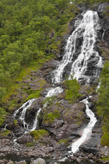 A beautiful waterfall in the forest with several smaller streams flowing over the rocks.