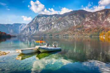Amazing  view  of  Bohinj Lake with boats during autumn .