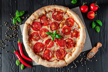 Pizza Margherita on black background, top view. Pizza Margarita with Tomatoes, Basil and Mozzarella...
