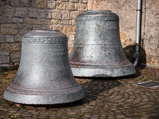 Two old church bells stand on a square