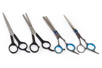 Several different professional stainless steel hair scissors on white background