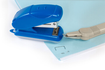 Small paper stapler and staple remover on stapled paper sheets