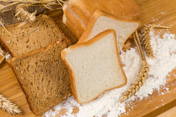 White and brown bread for toasting with ears and flour