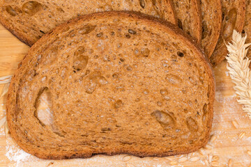 Slice of dark brown bread against the rest loaf