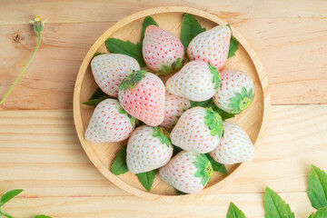 White and Pink snow Strawberries on wooden Background, Fresh Pink Snow Strawberry in wooden plate on wooden background.