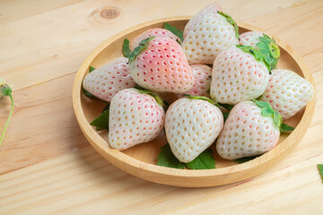 White and Pink snow Strawberries on wooden Background, Fresh Pink Snow Strawberry in wooden plate on wooden background.