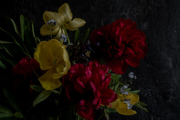 luxury bouquet dark red peonies and other spring flowers on a black background. Loy key photo